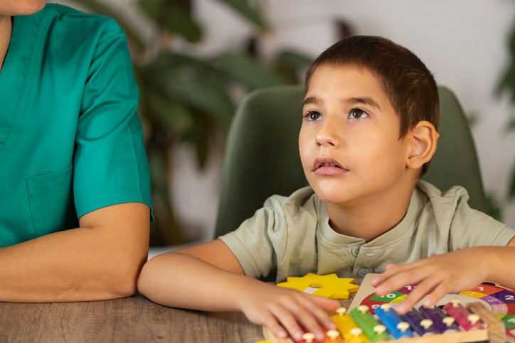 Child with signs of developmental delay during a learning activity in Houston, TX